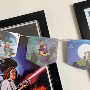 May include: A string of paper banners with illustrations from the movie Frozen. The banners feature characters from the movie, including Elsa, Anna, Kristoff, and Olaf. The text on one banner reads "They fell in love!"