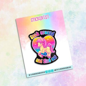 May include: A sticker featuring a cartoon unicorn with a rainbow heart and the text "Look around and find out".