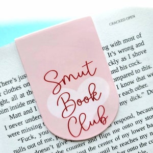 May include: Pink bookmark with a red heart and the text "Smut Book Club".