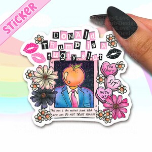May include: A sticker with the text "DONALD TRUMP is a fugly slut" in black letters. The sticker features a cartoon image of a person with an orange head, wearing a suit and tie, surrounded by flowers and hearts.
