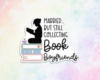 May include: A sticker with a black silhouette of a woman sitting on a stack of books and reading a book. The text on the sticker reads "Married... But Still Collecting Book Boyfriends".