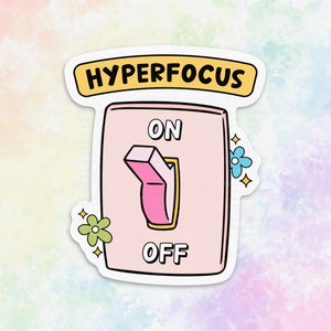 May include: A pink and white sticker with a light switch illustration. The switch is in the "on" position. The text "HYPERFOCUS" is above the switch and the words "ON" and "OFF" are below the switch.