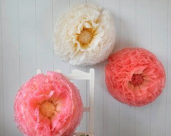 Three giant hand-dyed summery paper pompom flowers in red, yellow and pink