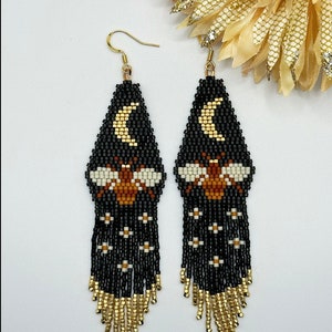 Bee with gold crescent moon fringe earrings.