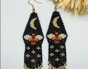 Bee with gold crescent moon fringe earrings.
