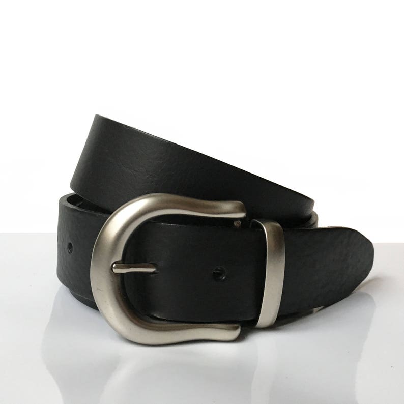 May include: A black leather belt with a silver buckle. The belt is folded in half and the buckle is visible.