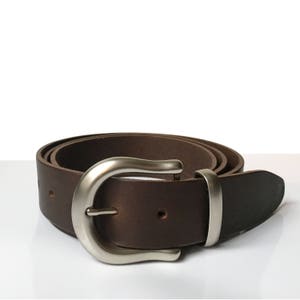 May include: A brown leather belt with a silver buckle. The belt is folded and the buckle is in focus.