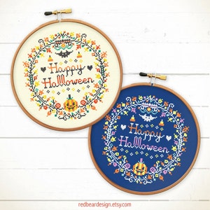 May include: Two cross-stitch hoops with Halloween wreaths. One is on cream fabric, the other on blue. Both feature a pumpkin, bat, and the words "Happy Halloween" in a decorative font. The hoops are set in wooden frames.