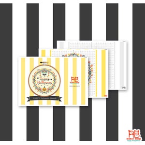May include: A cross-stitch pattern for a Happy Halloween wreath, displayed in a wooden embroidery hoop. The design features a wreath with a pumpkin, hearts, and the words "Happy Halloween." The background is yellow and white stripes.