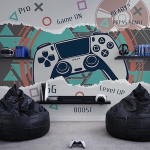 May include: A gaming-themed room with a large wall mural featuring a game controller graphic, geometric shapes, and the words "Game On," "Level Up," and "Boost." Two black bean bag chairs and a white game controller are in the foreground.
