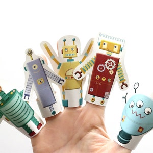 May include: Five colorful finger puppets shaped like robots. The robots are made of paper and have different designs and colors.