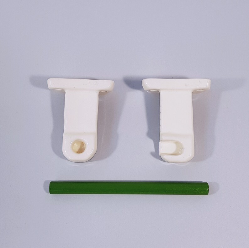 May include: Two white ceramic curtain rod brackets with a hook on one side and a hole on the other. A green metal curtain rod is included.