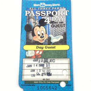 Puede incluir: Un pasaporte de Walt Disney World de 4 días azul y blanco para los tres parques. El pasaporte es válido para un huésped y tiene fechas para el 14 y 15 de enero de 1992. El pasaporte tiene una imagen de Mickey Mouse y el texto "Day Guest" en él.