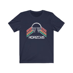May include: A navy blue t-shirt with a vintage-style graphic of a stylized sun with red, orange, yellow, green, and brown stripes. The text "HORIZONS" is printed below the graphic.