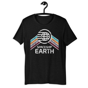 Op de afbeelding: Zwart T-shirt met een vintage-stijl grafische afbeelding van een globe met strepen en de tekst "Spaceship Earth".