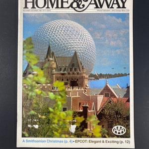 May include: A magazine cover featuring a photo of a large, silver geodesic dome with a blue sky and white clouds in the background. The magazine is titled "Home & Away" and the text "A Smithsonian Christmas (p. 4) • EPCOT: Elegant & Exciting (p. 12)" is printed at the bottom.