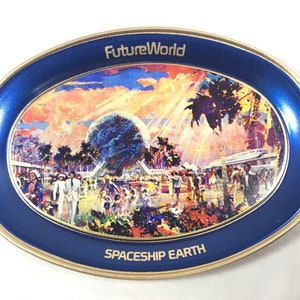 Peut inclure: Un plateau ovale en métal bleu et or avec une image colorée de Spaceship Earth au Future World d'Epcot. L'image comprend des palmiers, un monorail et des gens qui se promènent dans le parc. Le texte "Future World" et "Spaceship Earth" est imprimé sur le plateau.