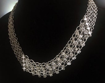 Collar de malla asimétrica de acero inoxidable y gunmetal con cadenas en capas, cuentas de vidrio forradas de plata y detalles de cristal en forma de diamante