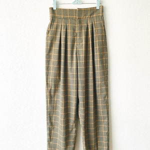 May include: A pair of high-waisted, wide-leg pants in a brown and yellow plaid pattern.