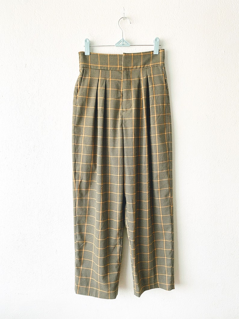 May include: A pair of high-waisted, wide-leg pants in a brown and yellow plaid pattern.