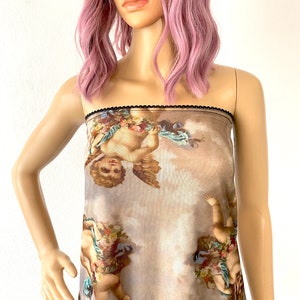 Puede incluir: Un top de malla marr&oacute;n transparente con ribete negro. El top presenta un estampado de querubines con alas y flores sobre un fondo nublado.