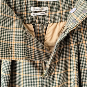 May include: Green and yellow plaid pants with a zipper closure and a label that reads "Urban Outfitters".
