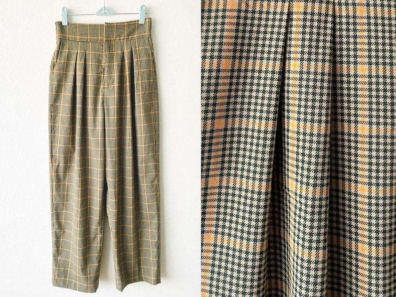 May include: A pair of high-waisted, wide-leg pants in a brown and yellow plaid pattern. The pants have pleats in the front and a straight leg.