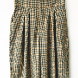 May include: A pair of high-waisted, pleated pants in a brown and yellow plaid pattern.