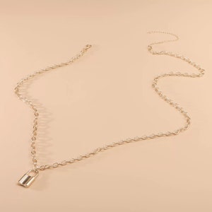 May include: A gold chain necklace with a small padlock pendant. The chain is made of small, linked circles.