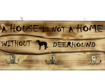 Scottish deerhound, a wooden wall peg, hanger with the picture of a dog and the words: "A house is not a home without..."