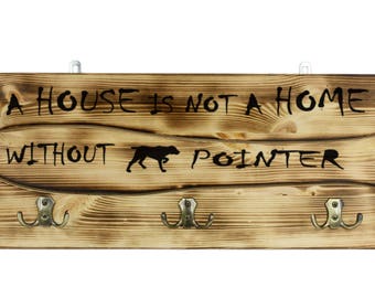 English Pointer, a wooden wall peg, hanger with the picture of a dog and the words: "A house is not a home without..."