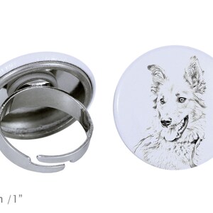 Peut inclure: Une bague ajustable en argent avec un bouton blanc représentant un croquis en noir et blanc de la tête d'un chien. Le bouton a un diamètre de 2,5 cm.