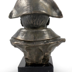 Op de afbeelding: Bronzen bustebeeld van een persoon met een tricorn. Het bustebeeld staat op een zwarte marmeren voet.