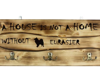 Eurasier, a wooden wall peg, hanger with the picture of a dog and the words: "A house is not a home without..."