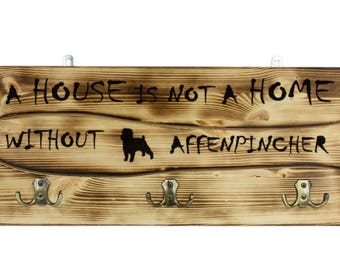 Affenpinscher, a wooden wall peg, hanger with the picture of a dog and the words: "A house is not a home without..."