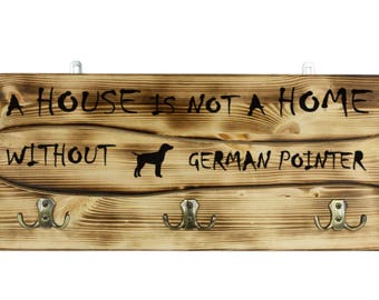 German Wirehaired Pointer, a wooden wall peg, hanger with the picture of a dog and the words: "A house is not a home without..."