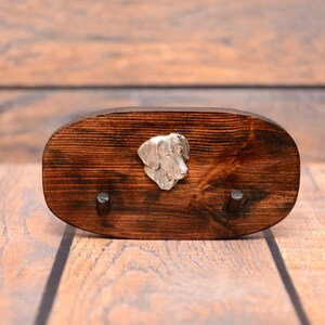 May include: A dark brown wooden key holder with two hooks and a silver dog head design.