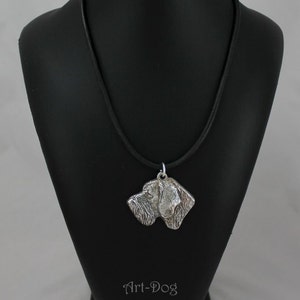 Può includere: Collana con ciondolo in argento con un profilo dettagliato della testa di un cane. Il ciondolo è su un cordoncino in pelle nera ed è esposto su un manichino nero. Il ciondolo misura 4,3 cm per 4,0 cm e pesa 28 grammi. Il testo "Art-Dog" è inciso sul manichino.