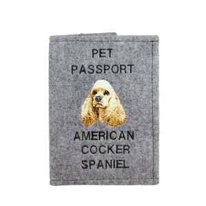 May include: Gray felt pet passport holder with an embroidered American Cocker Spaniel and the text "PET PASSPORT AMERICAN COCKER SPANIEL".