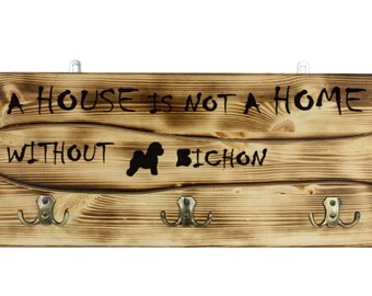 Bichon Frise, a wooden wall peg, hanger with the picture of a dog and the words: "A house is not a home without..."