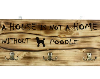 Poodle, a wooden wall peg, hanger with the picture of a dog and the words: "A house is not a home without..."