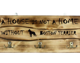 Boston Terrier, a wooden wall peg, hanger with the picture of a dog and the words: "A house is not a home without..."