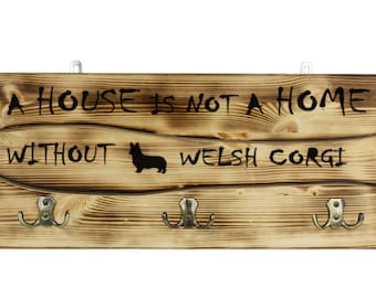 Pembroke Welsh Corgi , a wooden wall peg, hanger with the picture of a dog and the words: "A house is not a home without..."