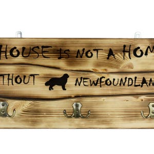Newfoundland, a wooden wall peg, hanger with the picture of a dog and the words: &quot;A house is not a home without...&quot;