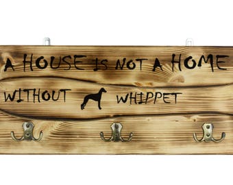 Whippet, a wooden wall peg, hanger with the picture of a dog and the words: "A house is not a home without..."