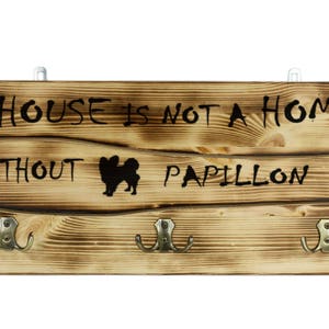 Papillon, a wooden wall peg, hanger with the picture of a dog and the words: &quot;A house is not a home without...&quot;