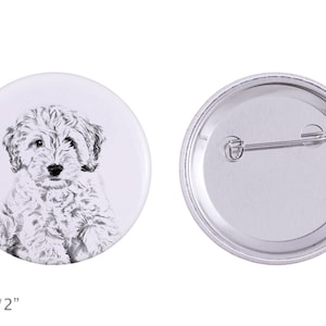 May include: A white button with a black and white illustration of a fluffy dog. The button is 2 inches in diameter.