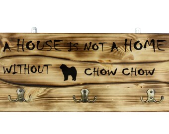 Chow chow, a wooden wall peg, hanger with the picture of a dog and the words: "A house is not a home without..."