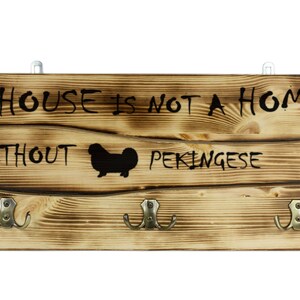 Pekingese, a wooden wall peg, hanger with the picture of a dog and the words: &quot;A house is not a home without...&quot;