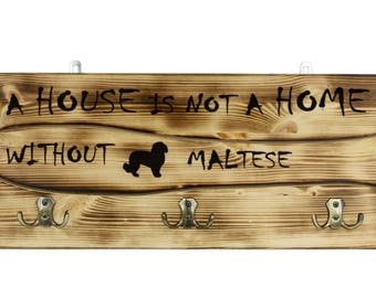 Maltese, a wooden wall peg, hanger with the picture of a dog and the words: "A house is not a home without..."